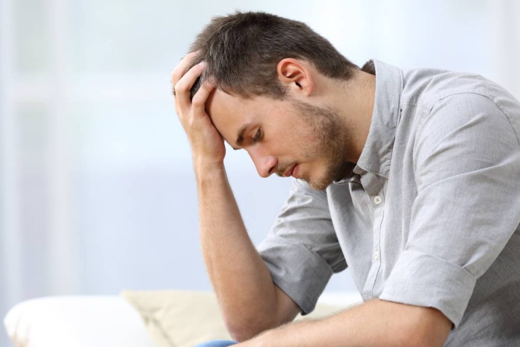 A male patient holding his head, struggling with anxiety near Lexington, KY